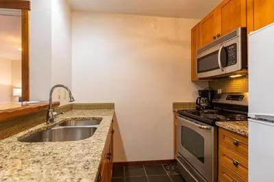 a kitchen with a sink and a microwave at Snow Creek Lodge by Fernie Central Reservations in Fernie