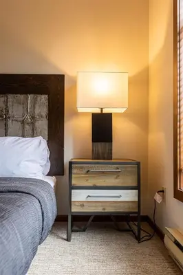 a bedroom with a bed and a nightstand with a lamp at Snow Creek Lodge by Fernie Central Reservations in Fernie