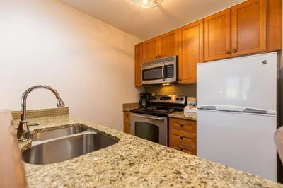 a kitchen with a sink and a microwave and a refrigerator at Snow Creek Lodge by Fernie Central Reservations in Fernie