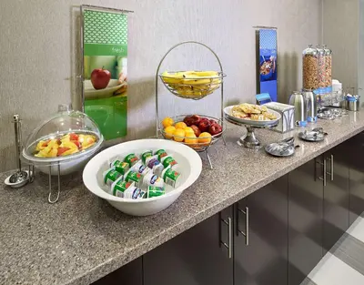 a counter with bowls of fruit and other food on it at Hampton Inn by Hilton Calgary Airport North in Calgary