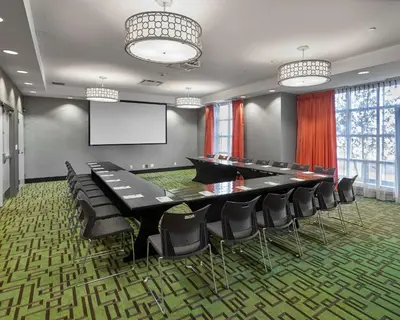 a conference room with a table and chairs and a screen at Hampton Inn by Hilton Calgary Airport North in Calgary
