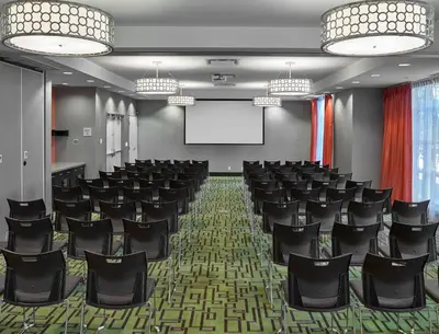 a conference room with black chairs and a screen at Hampton Inn by Hilton Calgary Airport North in Calgary