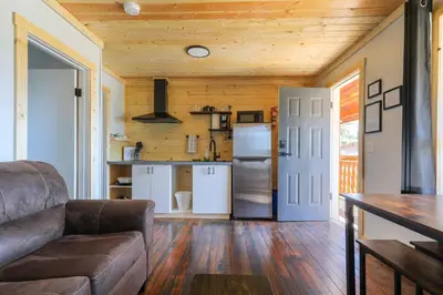 a living room with a couch and a kitchen at The Valley View Cabins and Event Center in Creston