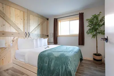 a bedroom with a large bed and a window at The Valley View Cabins and Event Center in Creston