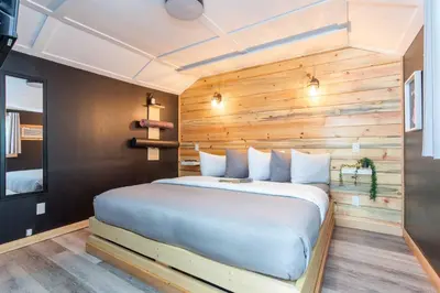 a bed in a room with a wooden wall at The Valley View Cabins and Event Center in Creston