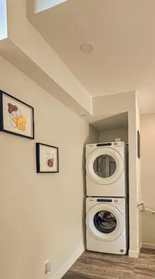 a laundry room with a washer and a washing machine at 2-in-1 Skyline MTN Retreat - Hot Tub - Pool - AC in Canmore