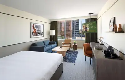 a hotel room with a bed and a living room at The Westley Calgary Downtown, Tapestry Collection By Hilton in Calgary