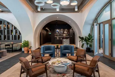 a lobby of a hotel with chairs and a table at The Westley Calgary Downtown, Tapestry Collection By Hilton in Calgary