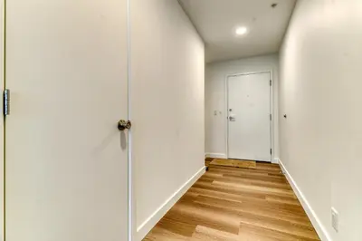 an empty hallway with a door and wooden floors at Kensington Suite 2bed & 1bath in Calgary