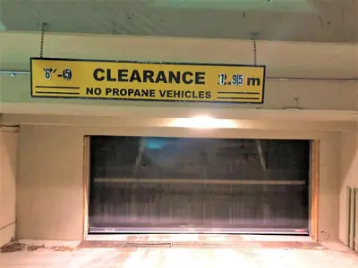 a sign above a garage with a no propane vehicles sign at Windtower Lodge FullKitchen-Kingbed Suite-MntView-UGParking-Walk2DT in Canmore