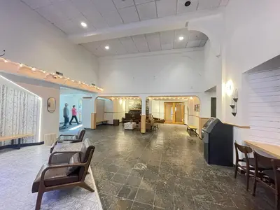 a large room with chairs and tables in a building at Windtower Lodge FullKitchen-Kingbed Suite-MntView-UGParking-Walk2DT in Canmore
