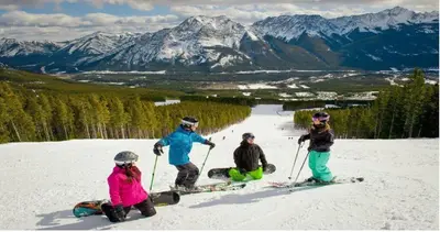 a group of four people on a ski slope at Windtower Lodge Queen Bed Suite-UGParking&Walking2DT in Canmore