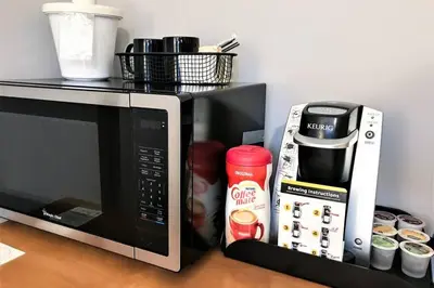 a microwave sitting on a counter next to a table at Windtower Lodge Queen Bed Suite-UGParking&Walking2DT in Canmore
