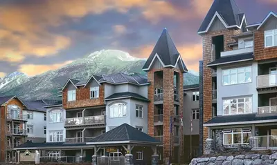 a group of buildings with a mountain in the background at Windtower Lodge Queen Bed Suite-UGParking&Walking2DT in Canmore