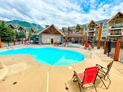 a swimming pool with two chairs and a resort at Sable Ridge Condos by StayIn in Radium Hot Springs
