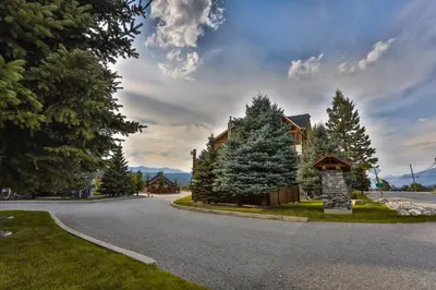 a house on a winding road with trees at Sable Ridge Condos by StayIn in Radium Hot Springs