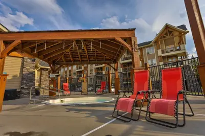 a patio with chairs and a swimming pool at Sable Ridge Condos by StayIn in Radium Hot Springs