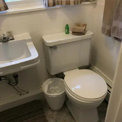 a bathroom with a white toilet and a sink at Holiday Lodge Cabins in Banff