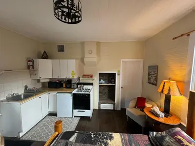 a kitchen with white appliances and a living room at Holiday Lodge Cabins in Banff