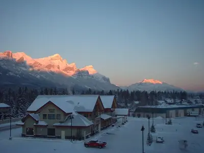 a town in the snow with mountains in the background at Apartment 406, Indigenous Artefacts in Canmore