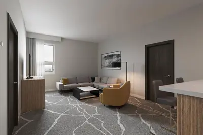 a living room with a couch and a table at Delta Hotels by Marriott Grande Prairie Airport in Grande Prairie