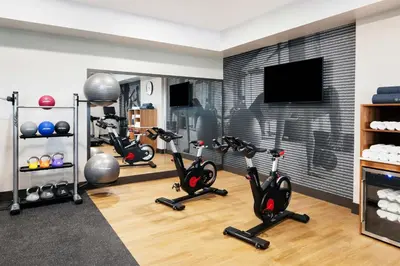 a gym with exercise bikes and a flat screen tv at Delta Hotels by Marriott Grande Prairie Airport in Grande Prairie