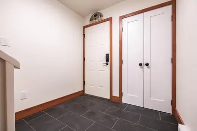 a hallway with two white doors and a tile floor at Snowberry by Outpost Whistler in Whistler