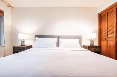 a bedroom with a large white bed with two lamps at Snowberry by Outpost Whistler in Whistler