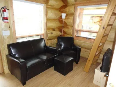 a living room with a leather couch and two chairs at Porteau Cove Olympic Legacy Cabins in Furry Creek