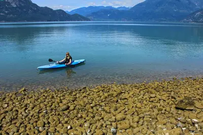a woman sitting on a kayak in a lake at Porteau Cove Olympic Legacy Cabins in Furry Creek