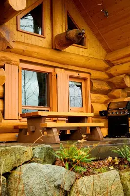a log cabin with a bench in front of it at Porteau Cove Olympic Legacy Cabins in Furry Creek