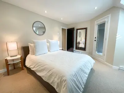 a bedroom with a large white bed and a mirror at 3BR in Gleneagle, Ski Storage, Wood Burning Fireplace, Free Shuttle in Whistler