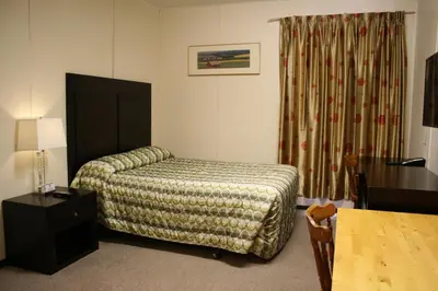 a hotel room with a bed and a table at CHINOOK INN in Rocky Mountain House