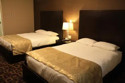 a hotel room with two beds and a lamp at CHINOOK INN in Rocky Mountain House