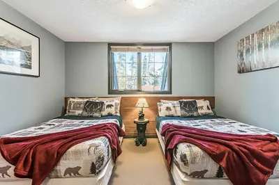 a bedroom with two beds and a window at Mystic Getaway in Canmore