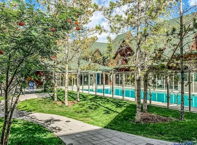 a house with a swimming pool in a yard with trees at Mystic Getaway in Canmore