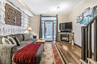 a living room with a couch and a fireplace at Mystic Getaway in Canmore