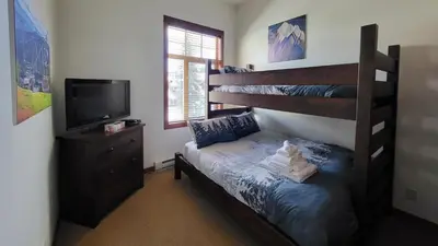 a bedroom with a bunk bed and a television at Settlers Crossing #41 by Bear Country in Sun Peaks