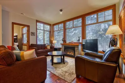 a living room with a couch and a fireplace at Settlers Crossing #08 by Bear Country in Sun Peaks