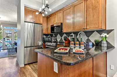 a kitchen with wooden cabinets and a counter top at The Lambeth by Samsara Resort Private Entry Panorama Top View 2BR and 2BTH in Canmore