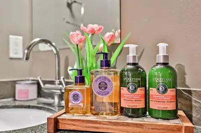 three bottles of soap sitting on a bathroom sink at The Versailles by Samsara Resort Top Luxury Top View 1300SQF 2BEDROOM 2BATHROM in Canmore