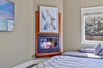 a living room with a fireplace and a bed at The Versailles by Samsara Resort Top Luxury Top View 1300SQF 2BEDROOM 2BATHROM in Canmore