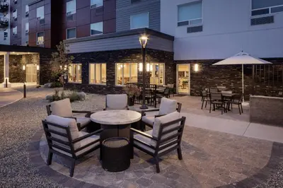 a patio with chairs and a table with an umbrella at TownePlace Suites by Marriott West Kelowna in West Kelowna