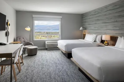 a hotel room with two beds and a desk and a window at TownePlace Suites by Marriott West Kelowna in West Kelowna