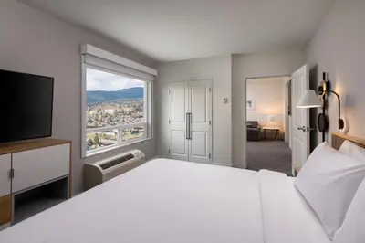 a bedroom with a large bed and a large window at TownePlace Suites by Marriott West Kelowna in West Kelowna