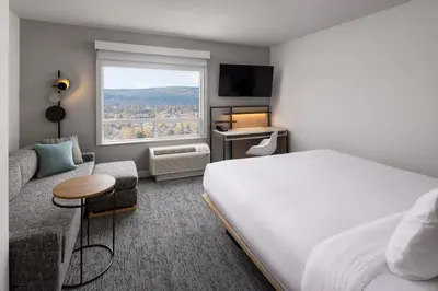 a hotel room with a bed and a couch and a window at TownePlace Suites by Marriott West Kelowna in West Kelowna