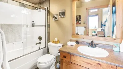 a bathroom with a toilet and a sink and a shower at Forest Lane Hideaway - Luxurious Family Friendly Home w Private Hot Tub in Big White