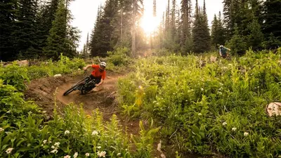 a man riding a dirt bike on a dirt trail at Fireside Lodge #215 by Bear Country in Sun Peaks