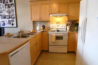 a kitchen with a sink and a stove top oven at Apartment 407, Contemporary Decor in Canmore
