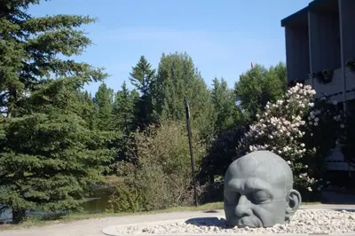 a statue of a head sitting in a park at Apartment 411, Antique Heritage in Canmore